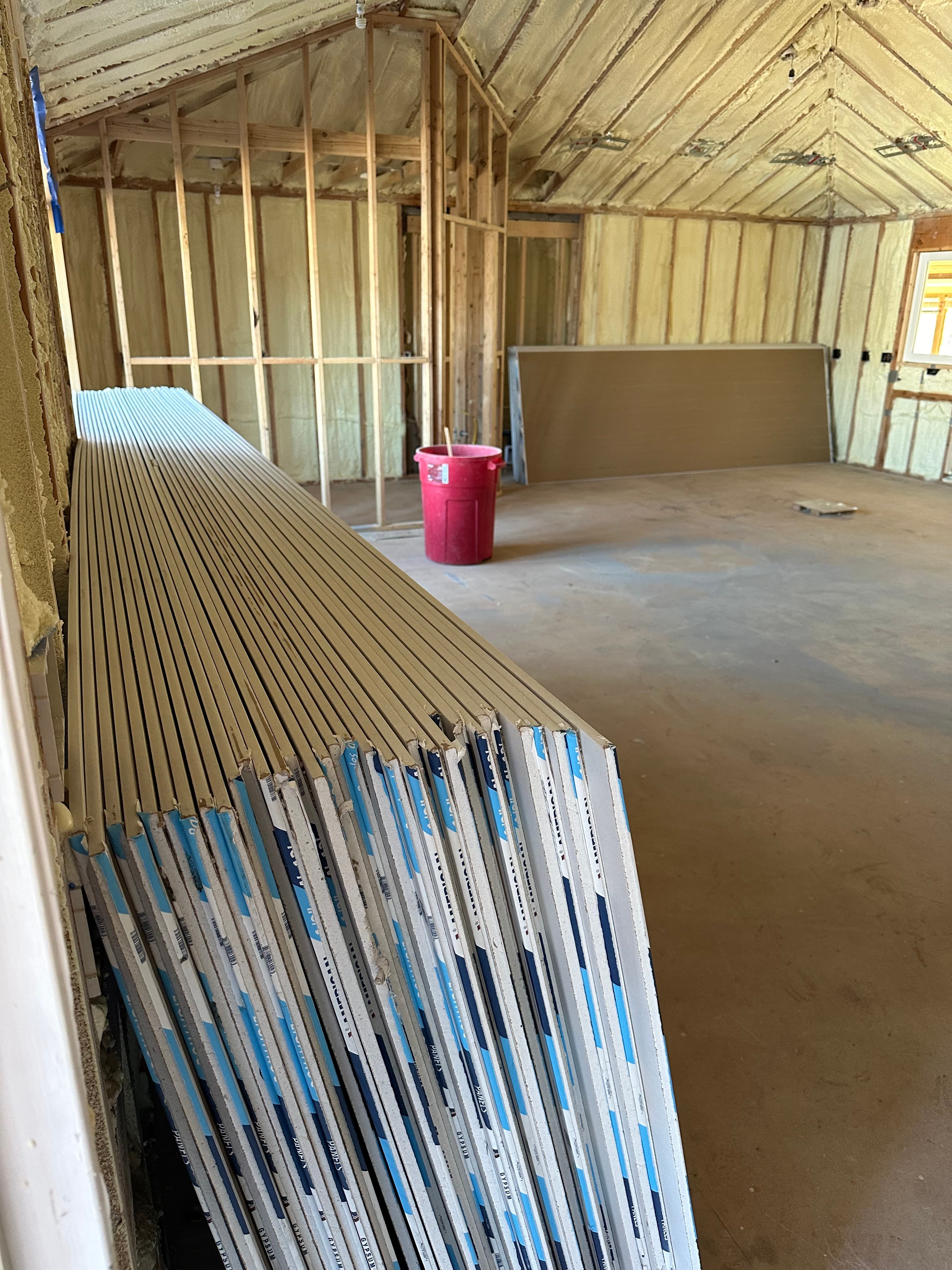 Main house interior with spray foam insulation installed between wall studs and roof framing